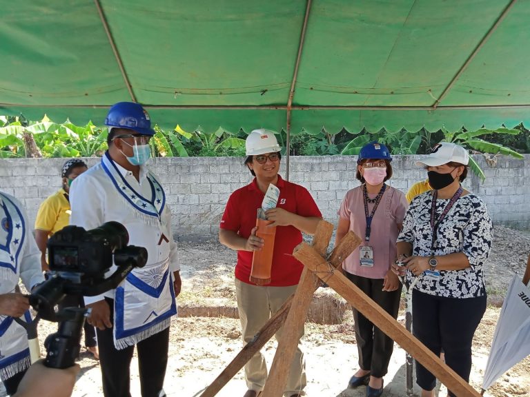 Allan Santos inserts a copy of the Groundbreaking Ceremony Program…