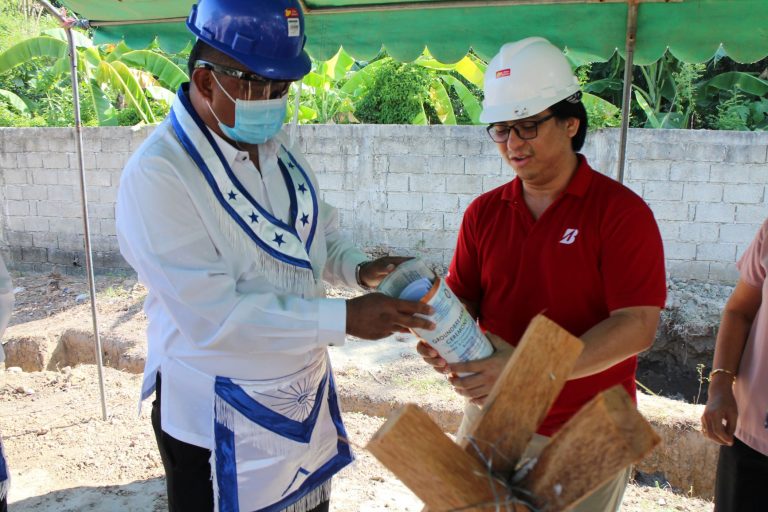 Worshipful Master Ernie Llanillo inserts a copy of the building plans.